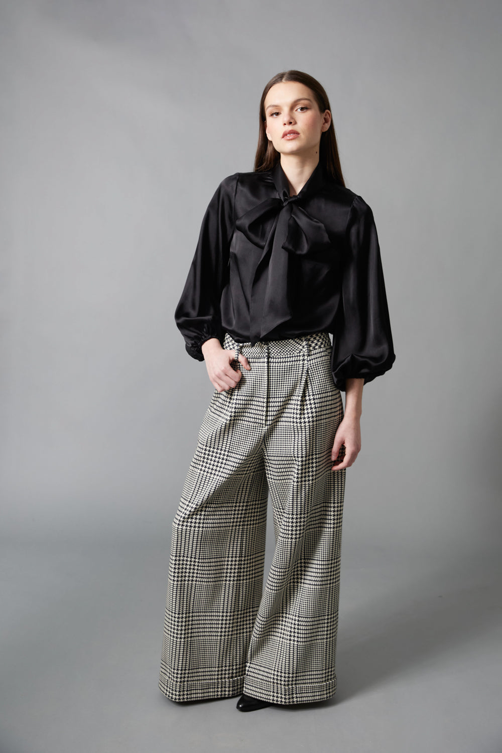 Woman in houndstooth trousers and black blouse
